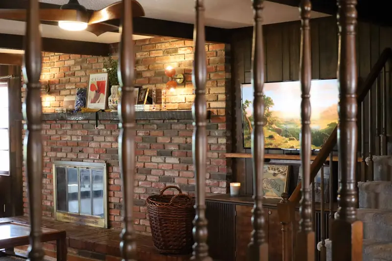 Brick fireplace seen through staircase spindles