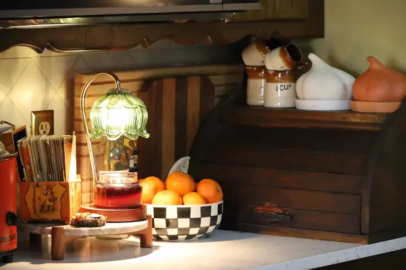 Kitchen counter with a vintage slow cooker, glass lamp and warm lighting